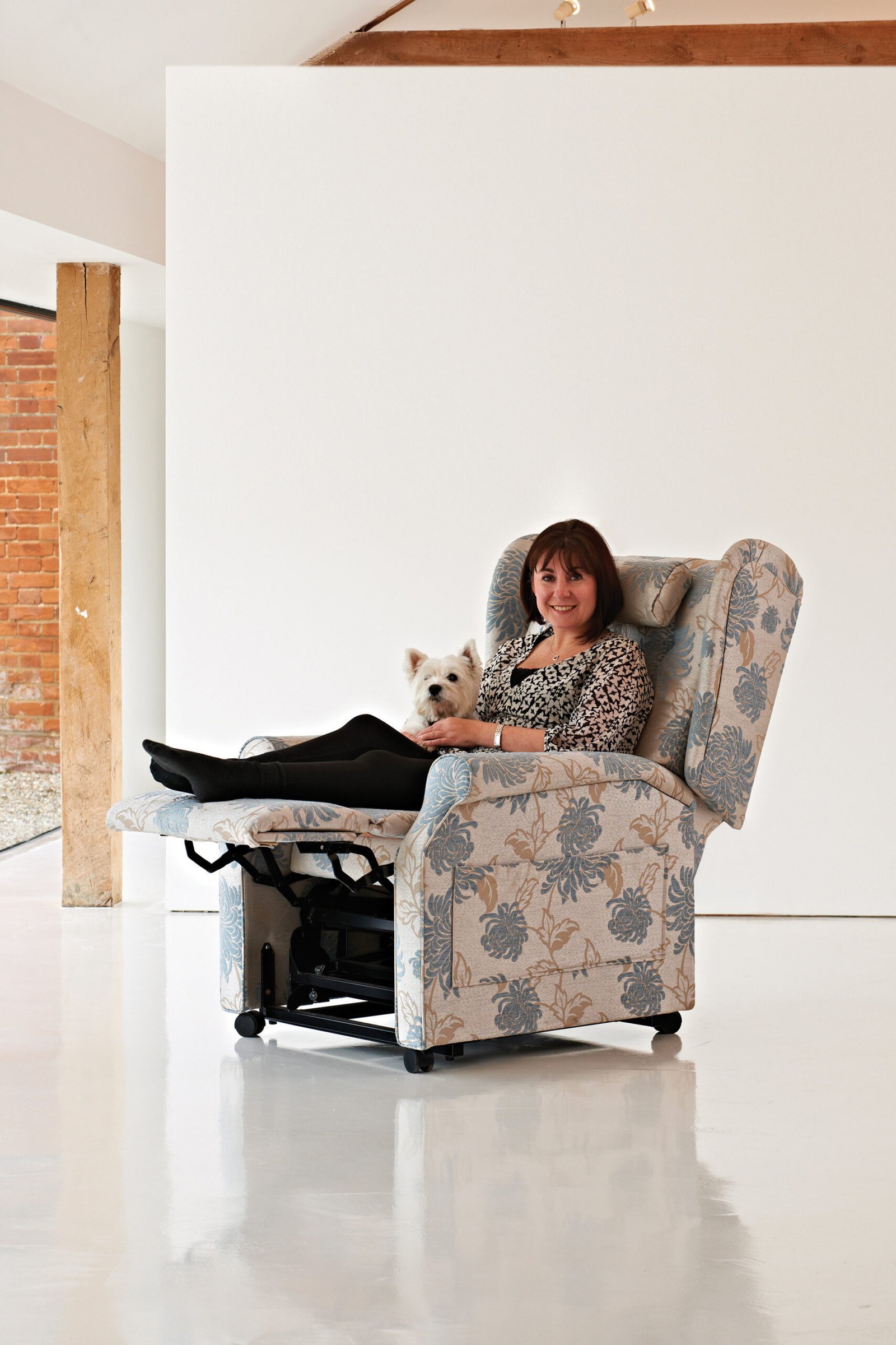 Woman in a riser recliner chair with her dog