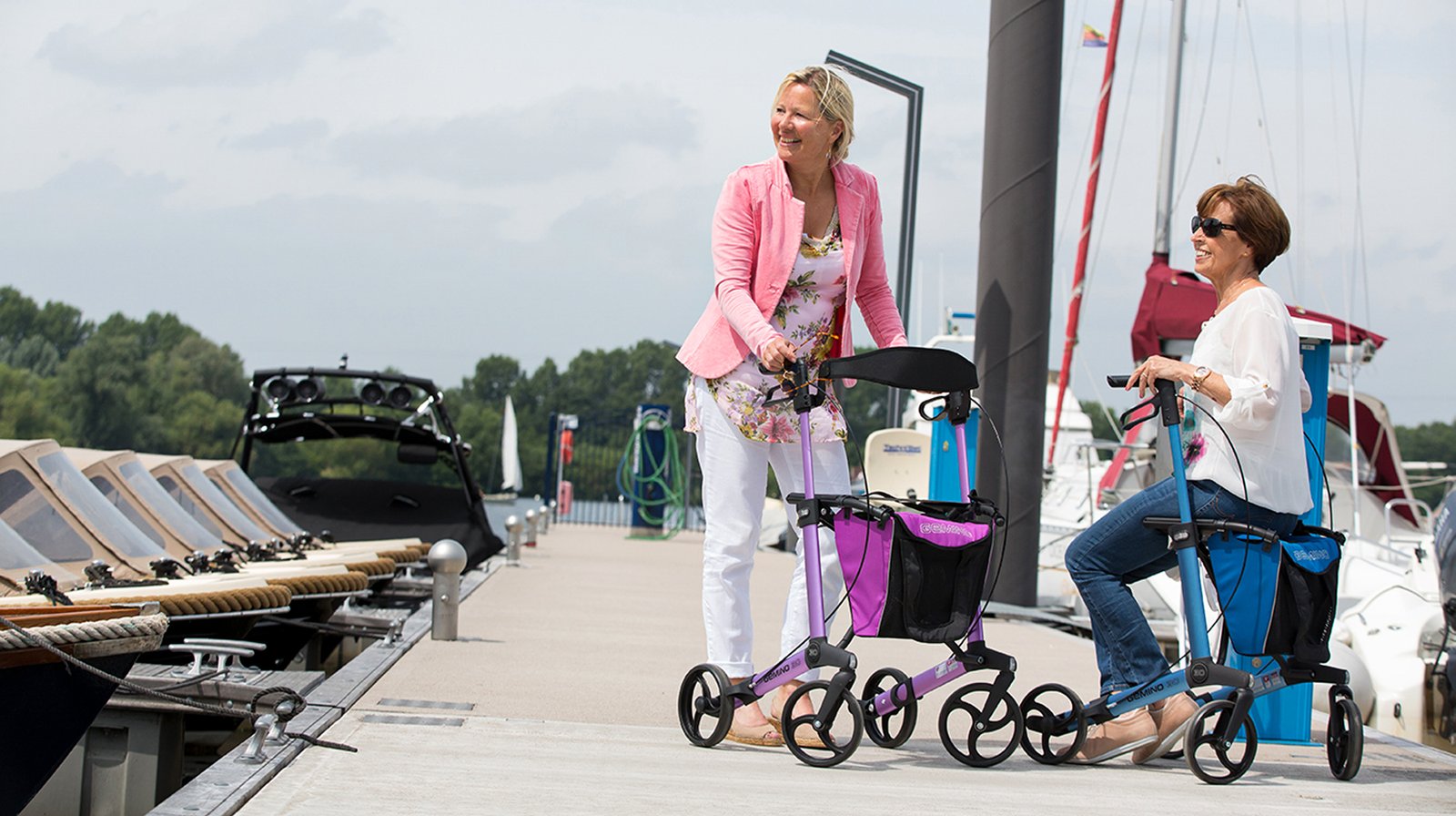 Two women using rollators together at the marina