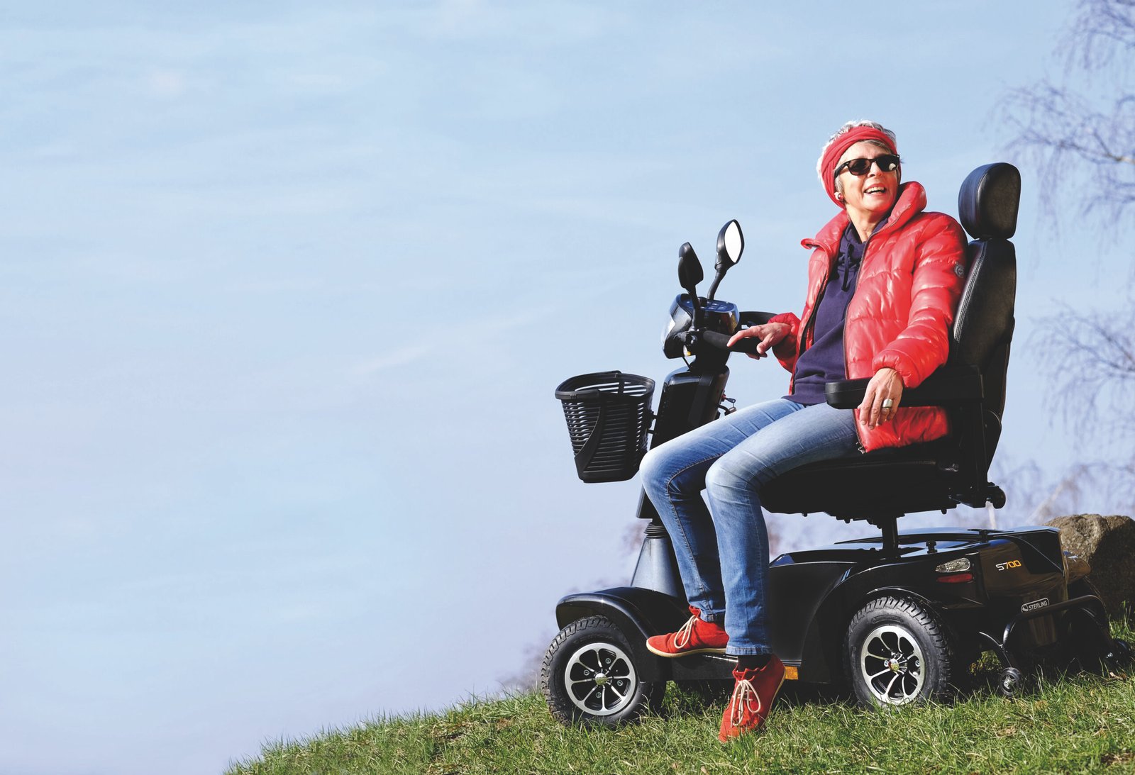 Woman on a mobility scooter enjoying an outdoor hillside view